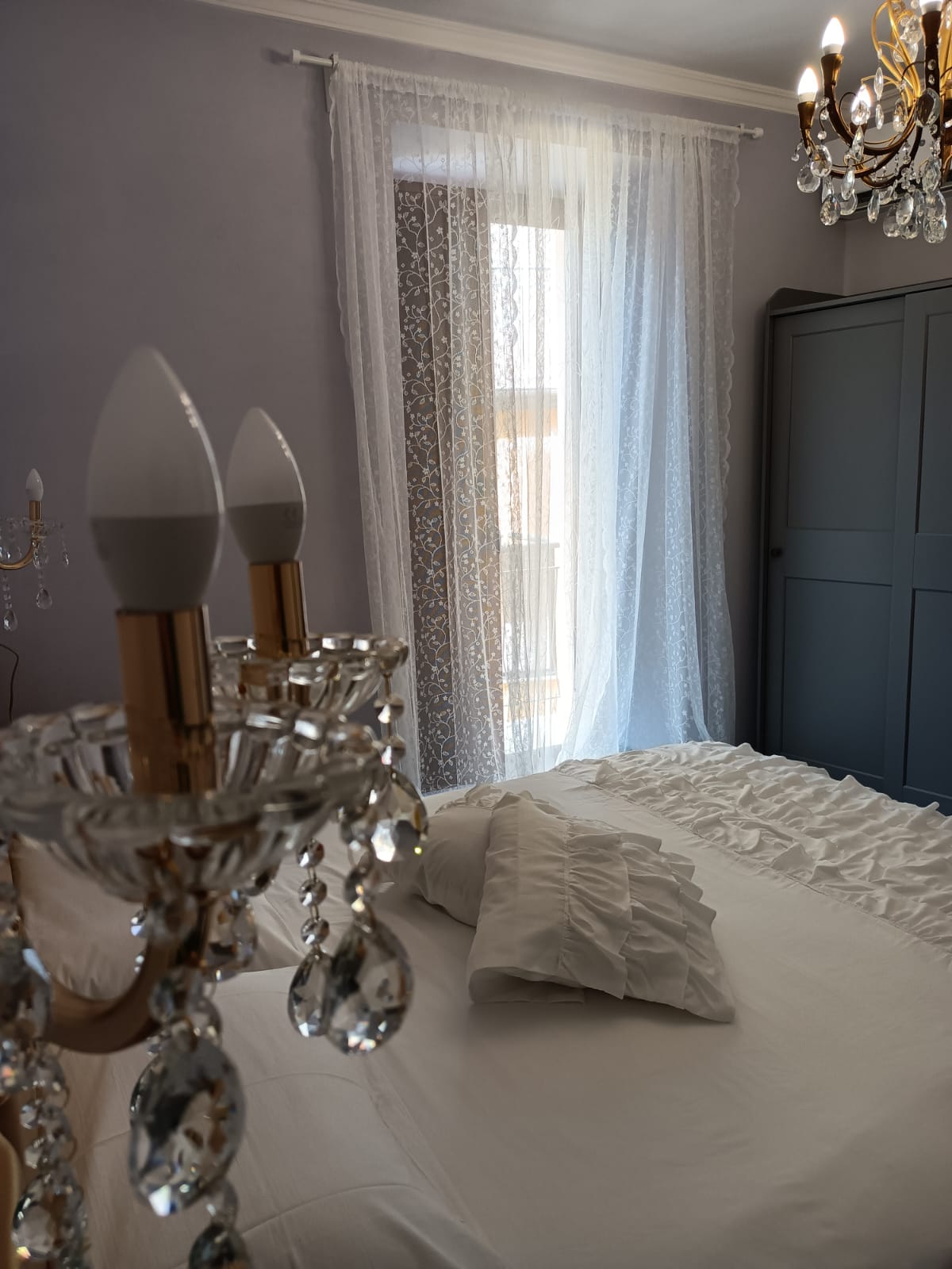 Camera Perla - atmosfera con applique di cristallo e tende in pizzo